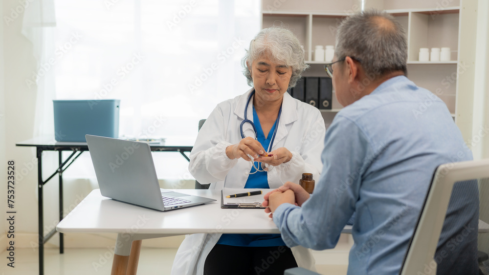 A senior female doctor gives advice to an elderly man at a health checkup meeting in the hospital. Specialist GPs provide medical advice to adult patients.