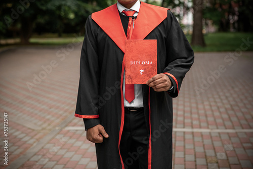 A university graduate student holds in his hands a red diploma with the honor of graduating from a medical institution of the University of Ukraine