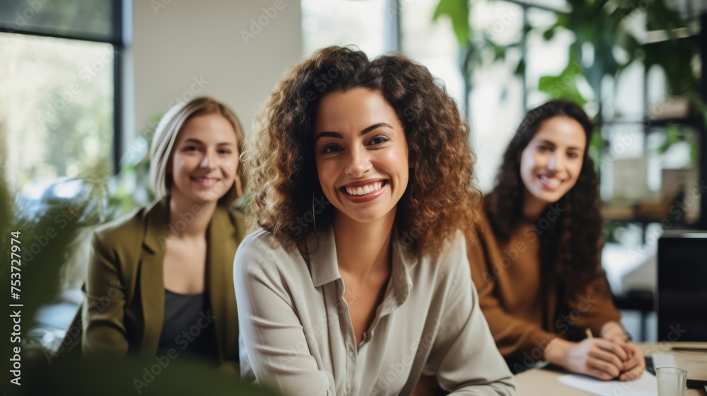 A group of diverse, confident, women working together, smiling, in an office, business environment A group of diverse, confident, women working together, smiling, in an office, business environment
