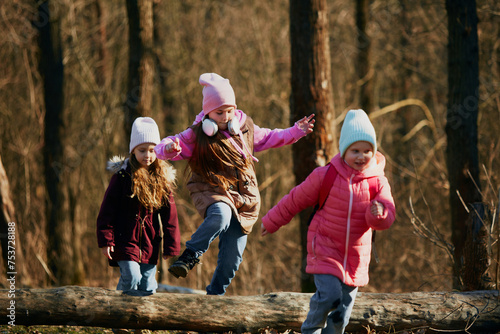 Pre-teens in winter outfit running  jumping energetically on dirt track outdoors. Environment lesson. Concept of outdoor activities for children s development  school  childhood  fashion and style. Ad