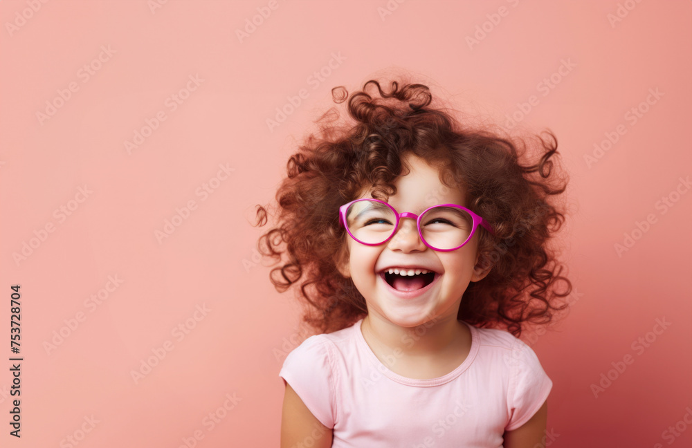 Smiling little curly girl in glasses, standing near pink background. Healthy smile concept. Smiling little curly girl in glasses, standing near pink background. Healthy smile concept.