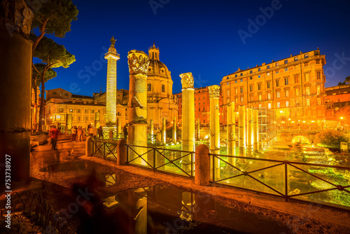 Forum - Roman ruins with column of Trajan illuminated at night, antique Rome Italy photo