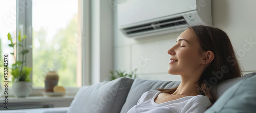 beautiful young woman relax at home on sofa with air conditioner