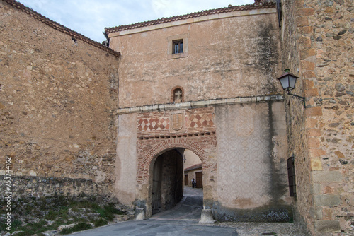 Entrance with a semicircular arch in the stone wall of the medieval village of Pedraza, province of Segovia.