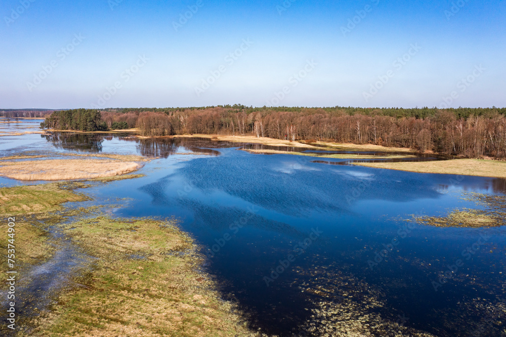 Flooded fields, meadows and forests during excessive rainfall. A river flooding fields and forests, view from a drone.. Flooded fields, meadows and forests during excessive rainfall. A river flooding fields and forests, view from a drone..