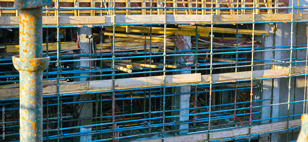 A construction site with scaffolding and a metal pipe. Scene is industrial and rugged
