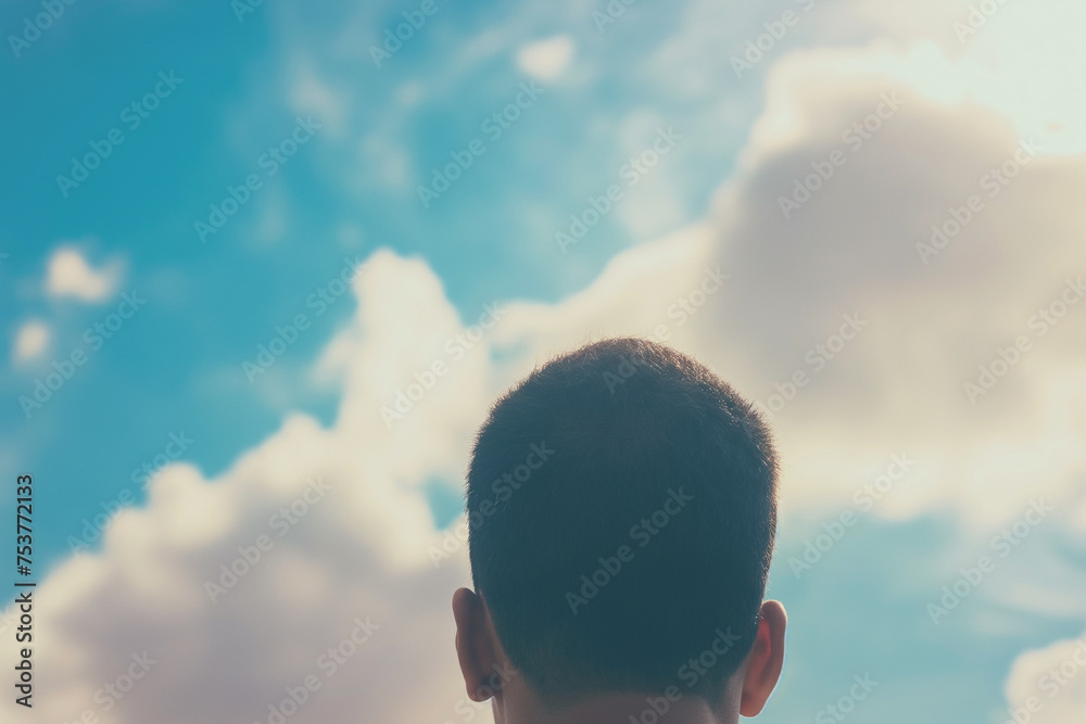 Man gazing at the sunlit cloudy sky during a bright summer day