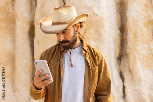 Calling by phone man with hat in nature brown clothes, adventures orgues photo