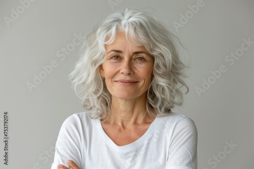 Smiling white-haired woman in a white t-shirt on a white background.