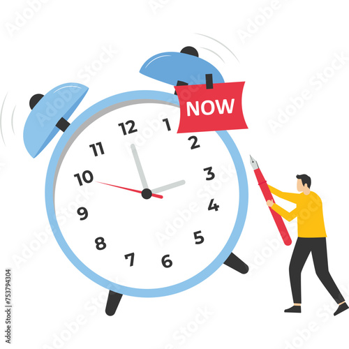 timekeeping concept, businessman with pencil after he wrote the word Now on a note and stuck it on a ringing alarm clock. Stop procrastinating, do it now to finish work or appointments on time.