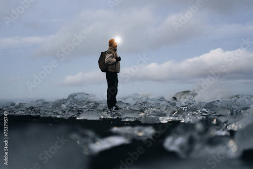 Solo traveler with backpack enjoy ice under cloudy sky in Iceland photo