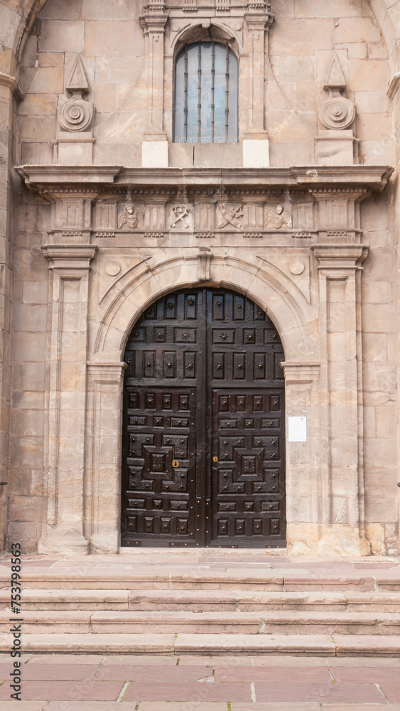 Puerta de madera antigua en arco de fachada de iglesia antigua