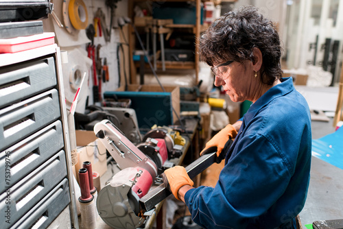 Mature woman working with metal at workshop photo