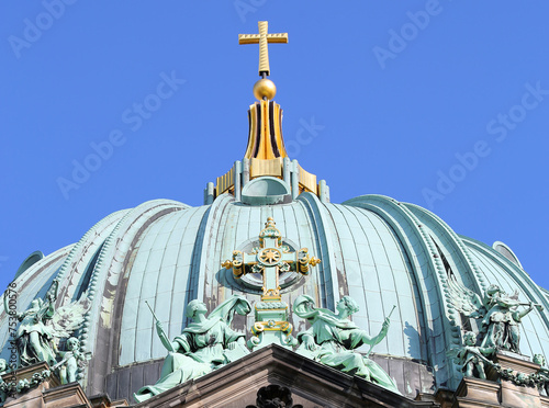 Rooftop Details of The Berlin Cathedral with Golden Cross and Blue Sky Background in Berlin, Germany photo