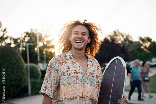Stylish man with skate on street photo