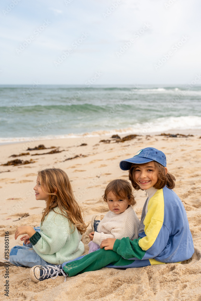 Sibling sitting together on the beach. Sibling sitting together on the beach.