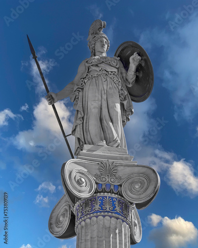 Athena statue, the ancient Greek goddess of wisdom and science, on a Corinthian style column with partly cloudy sky background. Athens, Greece. Filtered image. photo