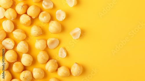 Delicious Macadamia nuts on a flat lay on a yellow background. Room for text photo