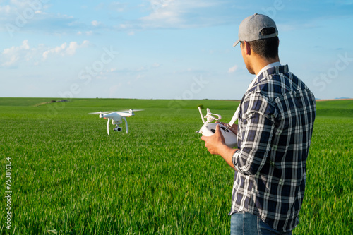 Modern Technologies in Agriculture. Farmer flying a drone over a young wheat field. High quality photo