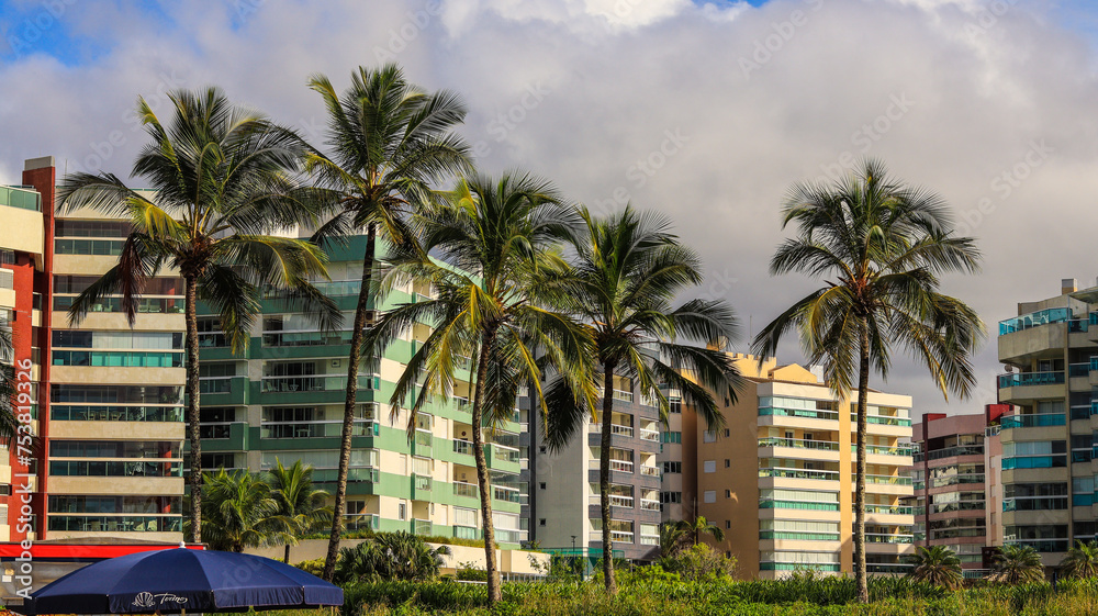 Árvores palmeiras em frente a prédios próximo a orla da rivieira de são lourenço, bertioga, sp, brasil