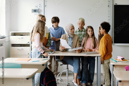 Schoolteacher checking homework of students  photo