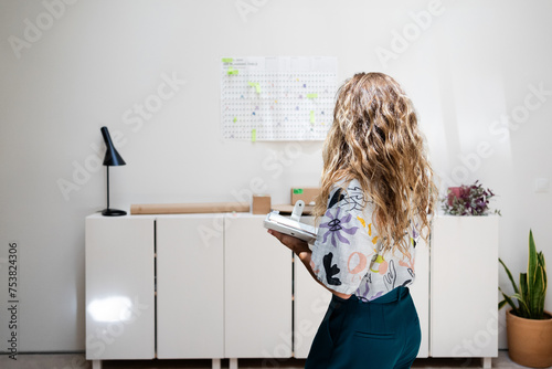  Woman planning weekly schedule at office  photo