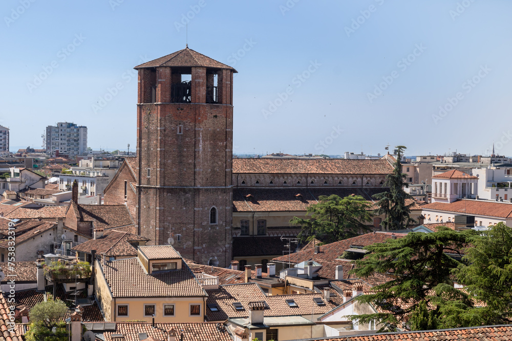 View of the tower of the cathedral and roofs of the city from the top of the garden of the castle of Udine, Italy.
