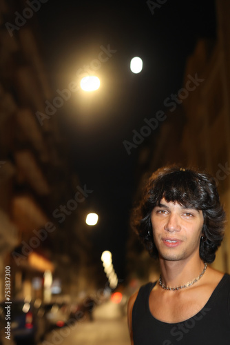 Portrait of young rock musician on the street enjoying nightlife photo