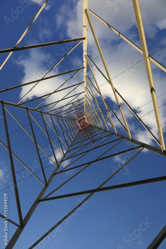 pylon with high voltage cables for the transport of electricity and white clouds on the sky photo