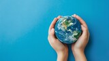 Care and responsibility for our planet are symbolized by two hands holding a little Earth on a bright blue background.