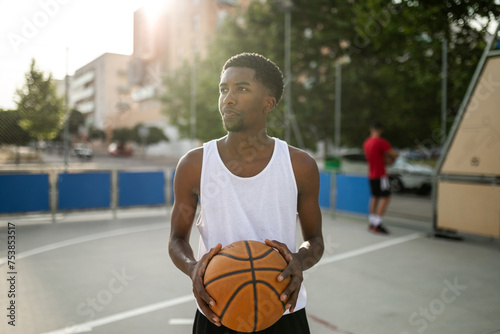 portrait of black teenager boy  playing basketball photo