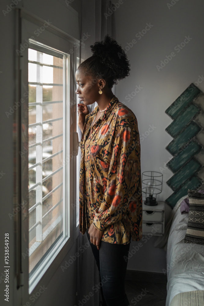 black woman at home looking out her bedroom window black woman at home looking out her bedroom window