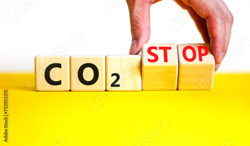 CO2 stop symbol. Concept word CO2 or CO2 stop on a beautiful wooden cubes. Beautiful yellow table white background. Businessman hand. Business ecological and CO2 stop concept. Copy space.