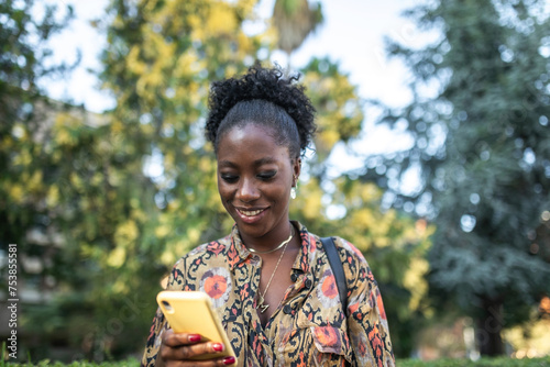 black woman with mobile phone outdoors photo