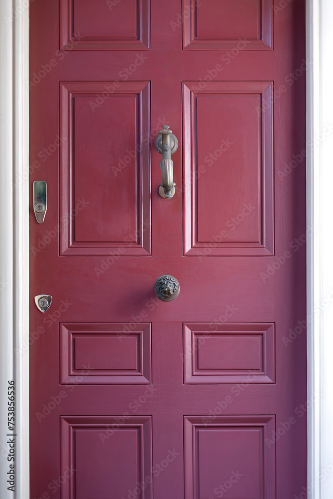 Fototapeta premium A close-up of a vibrant red door in New England, a bold focal point against the backdrop of traditional charm, encapsulating the region's inviting and picturesque aesthetic.