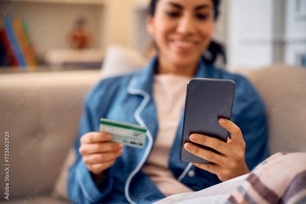 Close up of woman using cell phone and credit card for online banking at home. Close up of woman using cell phone and credit card for online banking at home.