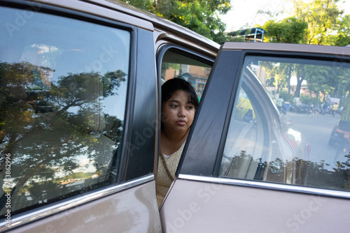 Young girl sit inside a car in a urban city at outdoors  photo