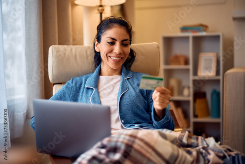 Happy woman e-banking with credit card and laptop at home. photo
