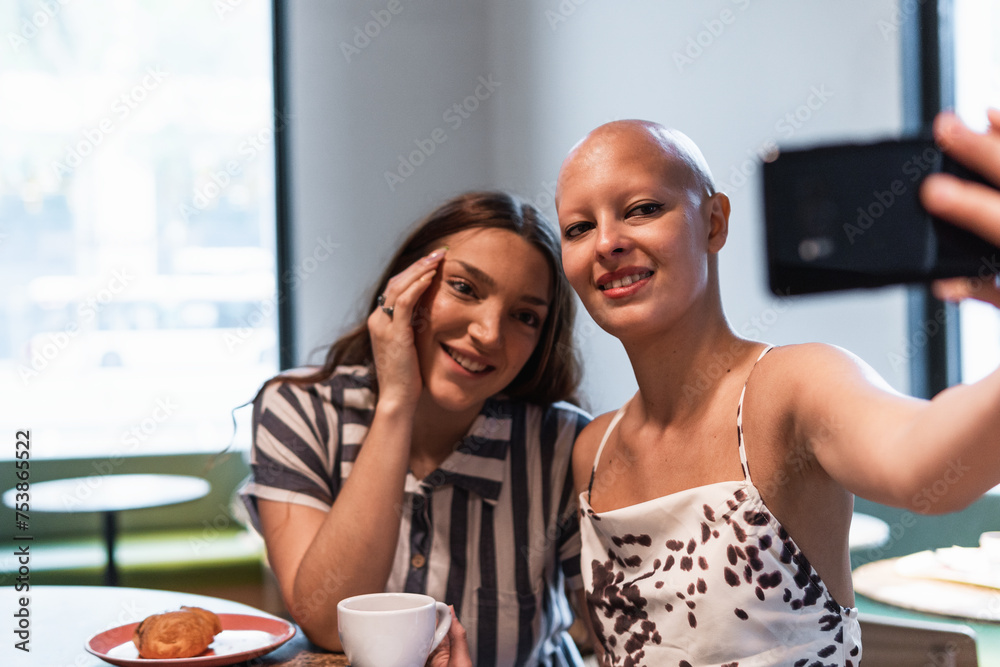 Delighted young female best friends resting in cafe and taking s Delighted young female best friends resting in cafe and taking s