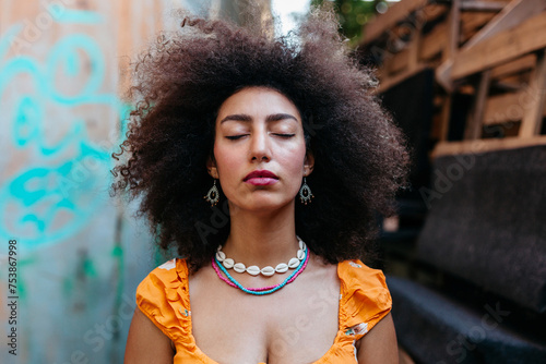 Egyptian woman with curly hair on street with closed eyes. photo