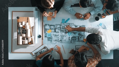 Top aerial view of project manager or civil engineer writing at blueprint and planning building design. Aerial view of architect working together at meeting table with document placed. Alimentation.