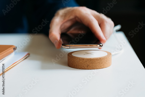 Man Putting Phone on Wireless Charger photo