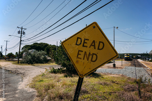 Dead End road sign near railway station in countryside
