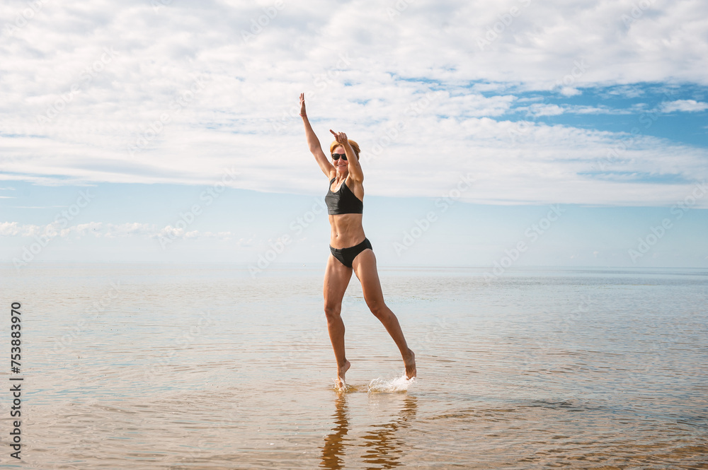 Happy sporty woman jumping in the water of sea Happy sporty woman jumping in the water of sea