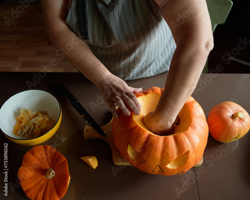 Carving: Woman Working On Face Of Jack-O-Lantern photo