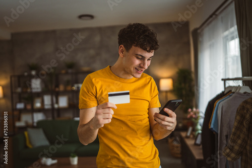 teenager young man at home use credit card shopping online