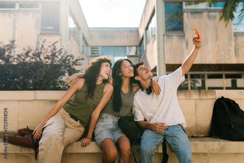 Cheerful multi-ethnic student friends taking a selfie with each other photo