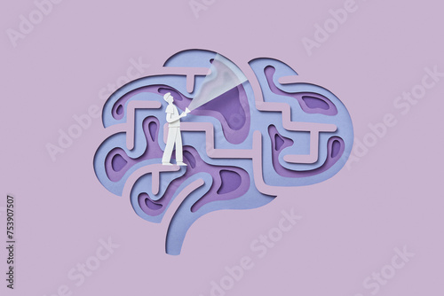 Papercraft male figure with flashlight walking inside human brain photo