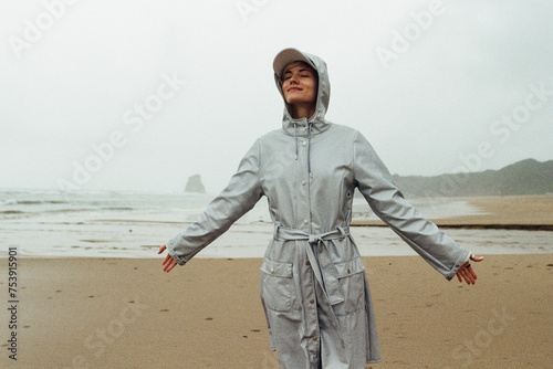 A  woman in the raincoat on the beach photo