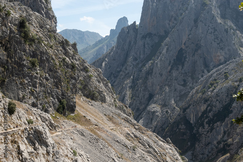 arid mountains crossed by a trail with trekkers on it photo